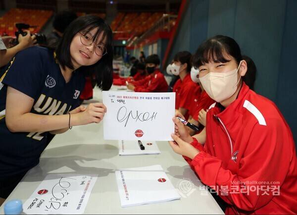페퍼저축은행 어르헝이 유소년 선수에게 사인해 주고 기념촬영을 하는 모습.