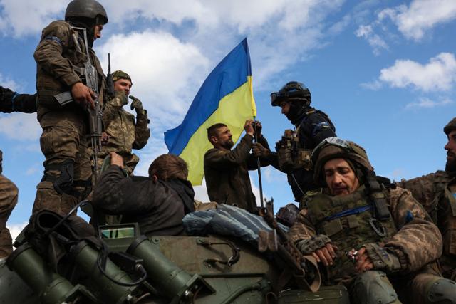 4일 우크라이나 도네츠크주 리만 인근 도로에서 우크라이나 군인들이 장갑차에 국기를 꽂고 있다. 리만=AFP 연합뉴스