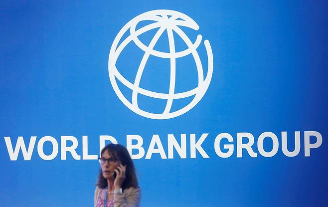 IMF의 세계 은행 로고 앞에 서있는 관계자. /연합뉴스