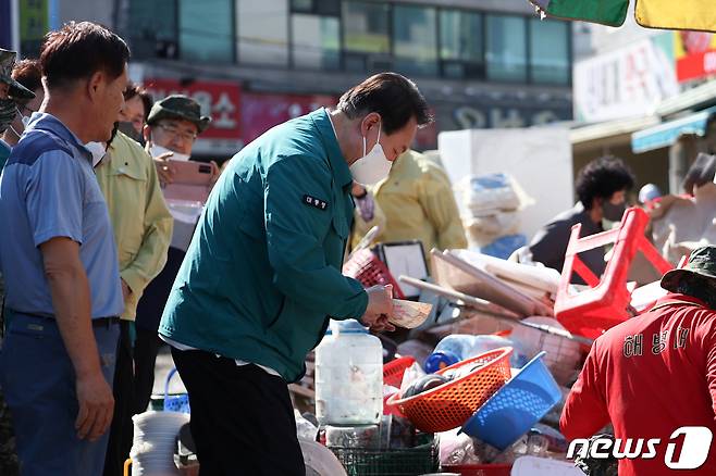 윤석열 대통령이 7일 오후 태풍 ‘힌남노’로 피해를 입은 경북 포항시 남구 오천시장을 방문해 수해 복구 작업을 돕고 있다. (대통령실 제공) 2022.9.7/뉴스1 ⓒ News1 오대일 기자