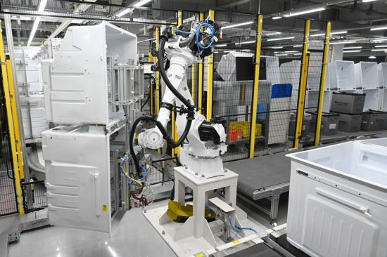 LG스마트파크 통합생산동 생산라인에 설치된 로봇팔이 무거운 냉장고 부품을 옮기는 모습.(사진제공=LG전자)
