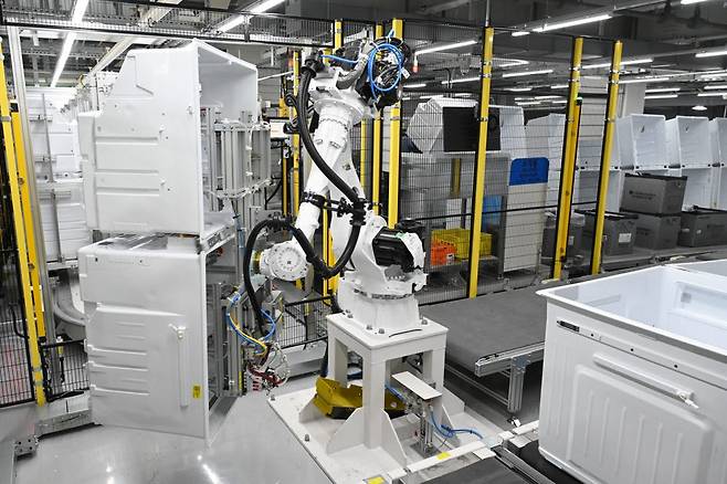 LG스마트파크 통합생산동 생산라인에 설치된 로봇팔이 무거운 냉장고 부품을 옮기고 있다.