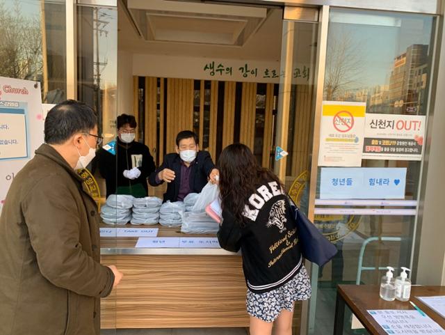 서울 종암동 성복중앙교회 교인들이 2020년 4월 대학생에게 무료 도시락을 나눠 주고 있다. 김영훈 기자
