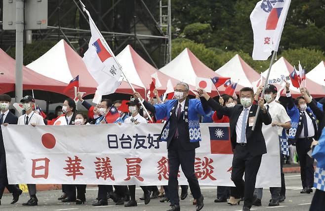 우정 과시하는 일 의원들 10일 열린 대만 111주년 국경절 행사에 참석한 일본 국회의원들이 일장기와 대만 국기를 흔들며 거리를 행진하고 있다. 타이베이 | AP연합뉴스