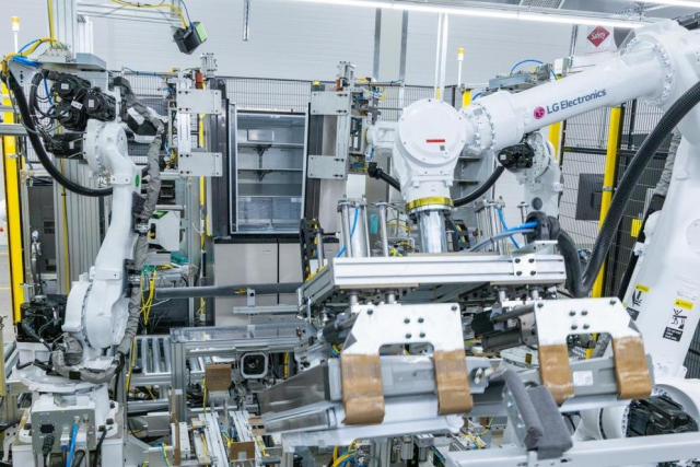 경남 창원의 LG 스마트파크 통합생산동 생산 라인에 설치된 로봇 팔이 냉장고 문을 들어 본체에 조립하고 있다.
