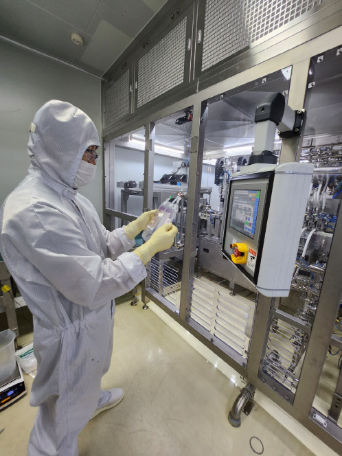 JW생명과학 직원이 TPN 3라인에서 생산된 종합영약수액제 신제품을 살펴보고 있다. JW생명과학 제공