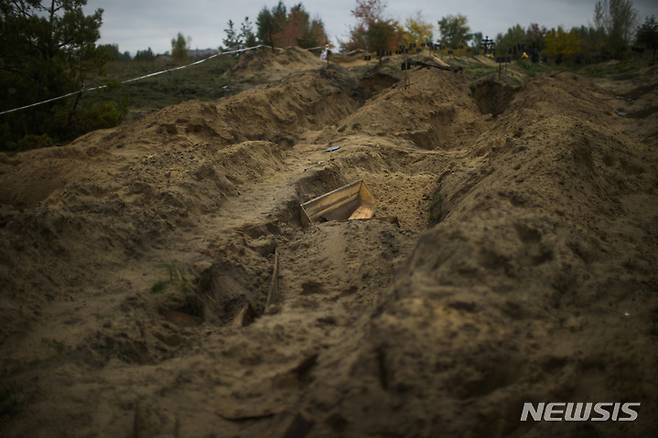 [리만=AP/뉴시스] 11일(현지시간) 우크라이나 리만의 집단 매장지에서 관이 버려져 있다. 우크라이나 발굴단은 이 곳에서 시신 발굴 작업을 진행했다. 2022.10.12.