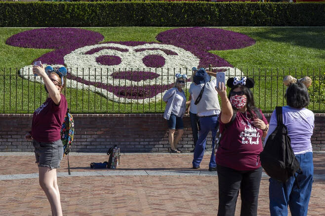 디즈니랜드를 찾은 이용객들이 미키마우스 조경을 배경으로 사진을 찍고 있다. /ⓒAFP=뉴스1