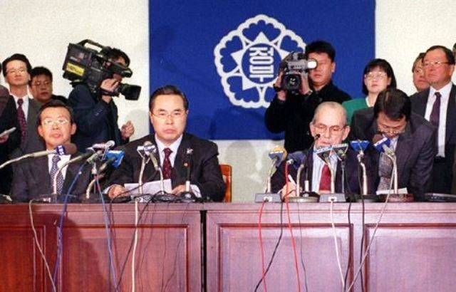 임창열 경제부총리 겸 재정경제원장관(앞줄 왼쪽)과 미셸 캉드쉬 IMF 총재(오른쪽)가 1997년12월3일 오후 세종로청사에서 내외신 보도진들이 지켜보고 있는 가운데 국제통화기금(IMF) 긴급자금지원 최종 협상 결과를 발표하고 있다./조선일보 DB