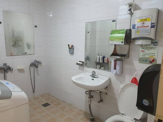 어느 학교 급식 노동자들이 이용하는 화장실의 모습. 한 공간 안에 샤워기와 세면기, 변기, 세탁기가 모두 함께 있다. 김영애씨 제공