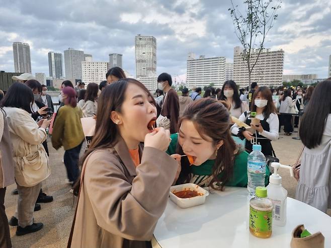 CJ ENM이 일본 도쿄 아리아케 아레나에서 개최한 '케이콘 2022 재팬'에서 떡볶이를 먹고 있는 일본 사람들. /도쿄=이민아 기자