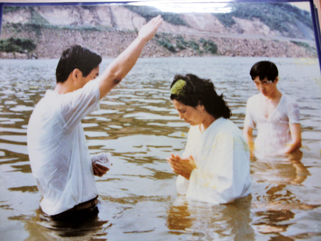 1973년 한기만(왼쪽) 목사가 서울 광나루 강에 들어가 성도에게 침례를 베풀고 있다.  여의도침례교회 제공