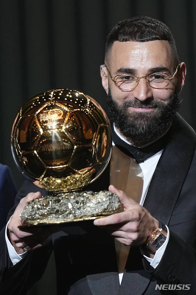 [파리=AP/뉴시스] 카림 벤제마(레알 마드리드)가 17일(현지시간) 프랑스 파리의 샤텔레 극장에서 열린 제66회 발롱도르 시상식에서 남자 발롱도르 트로피를 받고 포즈를 취하고 있다. 벤제마는 지난 시즌 라리가 32경기 27골 12도움으로 리그 득점왕, 챔피언스리그에서도 12경기 15골로 득점왕을 차지했다. 2022.10.18.