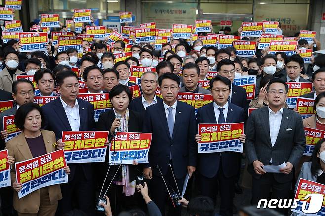 더불어민주당 의원들이 19일 오후 압수수색 중인 서울 여의도 더불어민주당사 앞에서 항의 손 피켓을 들고 있다. 서울중앙지검은 이날 대장동, 위례신도시 개발사업 특혜 의혹 사건과 관련해 민주당사 내 김용 민주연구원 부원장의 사무실 압수수색을 시도 했다. 2022.10.19/뉴스1 ⓒ News1 이재명 기자