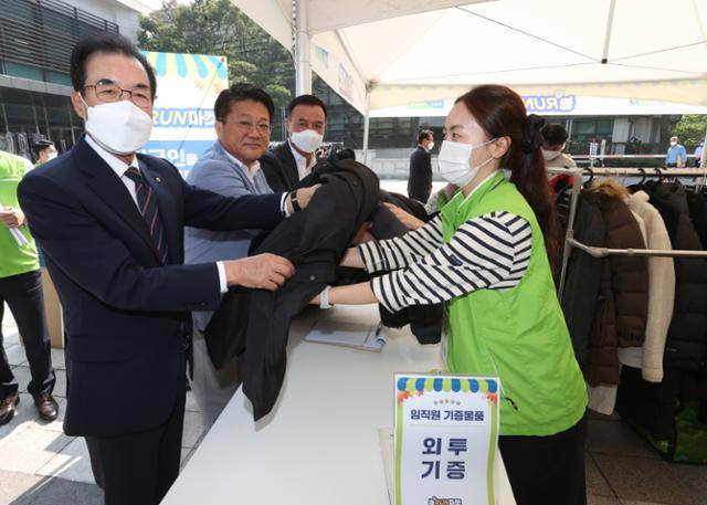 이성희 농협중앙회장(왼쪽)이 지난달 30일 서울 중구 농협중앙회 광장에서 열린 임직원 나눔장터 '농RUN마켓'에서 겨울 외투를 기부하고 있다. 농협중앙회 제공