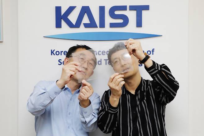 이승섭(왼쪽) 교수와 윤준보 교수가 투명 스마트 복합 필름을 들어보이고 있다.[KAIST 제공]