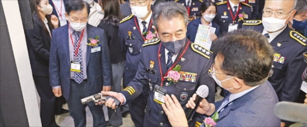 19일 인천 송도 컨벤시아에서 열린 ‘제4회 국제치안산업대전’에서 SNT모티브 관계자가 윤희근 경찰청장에게 신형 권총인 STRV9 9㎜ 권총을 설명하고 있다.  /SNT모티브  제공