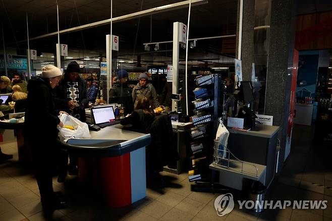 정전 속에 쇼핑하는 우크라이나 시민들 (하르키우 로이터=연합뉴스) 17일(현지시간) 우크라이나 하르키우에 정전 사태가 발생한 가운데 하르키우 시민들이 슈퍼마켓에서 쇼핑을 하고 있다. 2022.10.20 photo@yna.co.kr