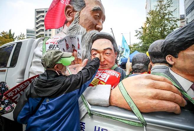 22일 서울 중구 태평로에서 열린 촛불행동 김건희 특검 윤석열 퇴진 11차 전국집중 촛불대행진에서 참가자들이 집회장소에 설치된 윤석열 대통령 조각상 앞에서 사진을 찍고 있다.ⓒ뉴시스