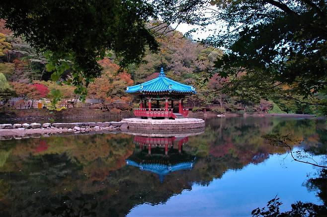 A traditional Korean pavilion, Uhwajeong, is reflected on a lake. (Lee Si-jin/The Korea Herald)