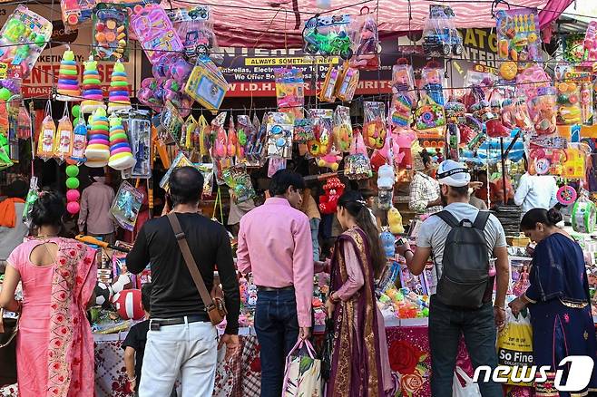 지난 21일(현지시간) 인도 암리차르의 시장에서 힌두교 최대 축제인 '디왈리(Diwali)'를 기념하기 위한 장식물을 구매하는 사람들. 22.10.21 ⓒ AFP=뉴스1 ⓒ News1 김예슬 기자