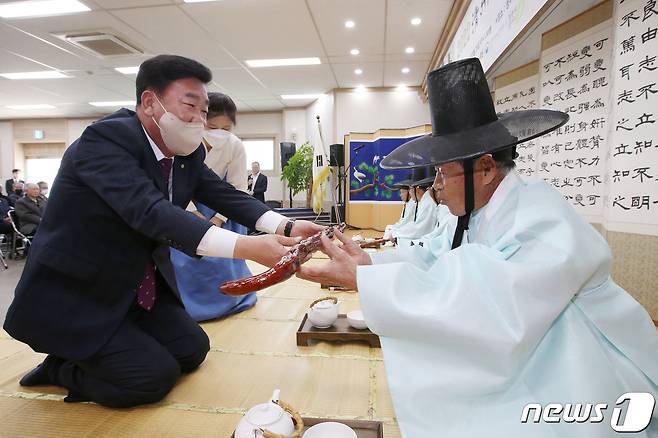 이범석 청주시장(왼쪽)이 25일 청주향교 충효관에서 열린 기로연(耆老宴) 행사에 참석해 노인 공경의 의미를 담아 지팡이를 전달하고 있다.(청주시 제공).2022.10.25/뉴스1