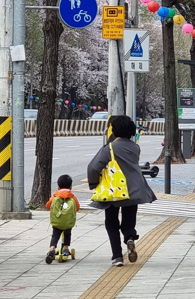 할머니와 함께 킥보드를 타고 등원하는 손자ⓒ