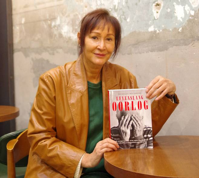 네덜란드 저널리스트 그리셀다 몰러만스가 지난 20일 인터뷰 도중 2020년 출간한 일본군 위안부 피해자 관련 책 <레이븐스 랑 오르로흐>(Levenslang Oorlog)를 소개하고 있다. 이진주 기자