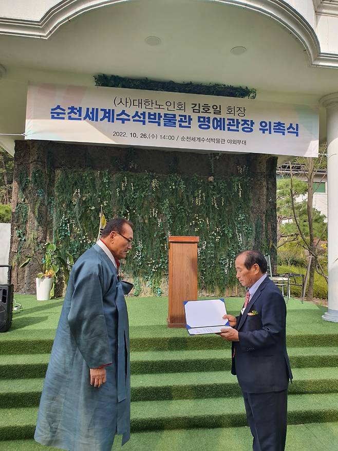 박병선(오른쪽) 순천세계수석박물관장이 김호일 대한노인회장에게 순천세계수석박물관 명예관장 위촉장을 전달하고 있다.