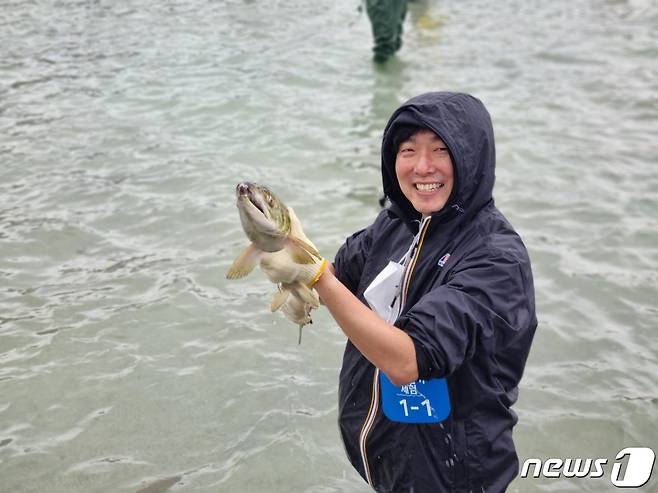 28일 강원 양양군 남대천 일원에 마련된 2022 양양연어축제 연어맨손잡기 체험행사에 참여한 방문객들이 잡은 연어를 들어올리고 있다. 2022.10.28/뉴스1 ⓒ News1 윤왕근 기자