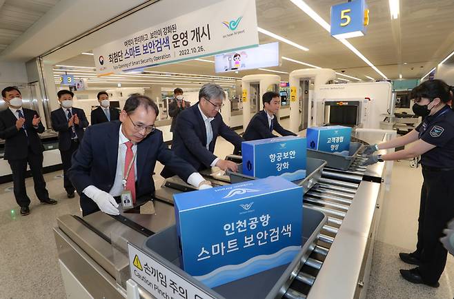 26일 인천공항 제1여객터미널 3번 출국장에서 열린 스마트 보안검색장 오픈 기념식에서 참석자들이 보안검색을 위해 바구니를 투입하고 있는 모습