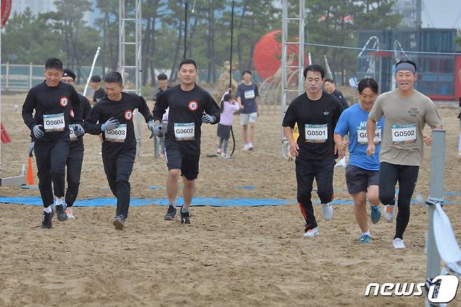 29일 경북 포항시 북구 영일대해수욕장 백사장 특설경기장에서 열린 '제2회 킹오브 더 포항'에 출전한 선수들이 출발 신호에 맞춰 달려나가고 있다. 이번 경기는 10㎏ 모래주머니를 들고 왕복 40m 달리기, 그물언덕 오르기, 80m 포복, 외줄로프, 공중그네, 바다에 설치된 80m 폰툰 위 달리기 등 12개 코스에서 그룹전과 개인전으로 진행된다.2022.10.29/뉴스1 ⓒ News1 최창호 기자