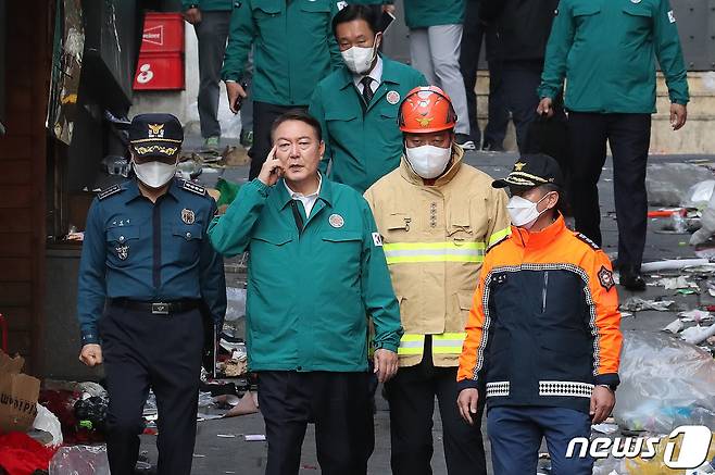 윤석열 대통령이 30일 오전 서울 용산구 이태원 핼러윈 압사사고 현장을 찾아 소방과 경찰의 설명을 들으며 살펴보고 있다. 윤 대통령은 이날 대국민 담화를 통해 "오늘부터 사고 수습이 일단락될 때까지 국가애도기간으로 정하고 국정의 최우선순위를 본 건 사고의 수습과 후속조치에 두겠다＂고 말했다. 2022.10.30/뉴스1 ⓒ News1 임세영 기자