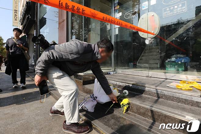 30일 오후 서울 용산구 이태원 압사 사고 현장 인근을 찾은 한 시민이 국화꽃을 놓고 있다. 이태원 압사사고로 발생한 인명피해는 이날 현재 사망 151명, 중상 19명, 경상 63명이다. 2022.10.30/뉴스1 ⓒ News1 임세영 기자