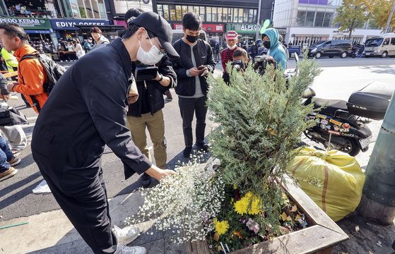 이태원 참사가 일어난 서울 용산구 이태원 해밀튼호텔 옆 골목 인근에 30일 부산에서 찾아왔다는 20대 직장인이 꽃다발을 놓고 있다. 김성룡 기자