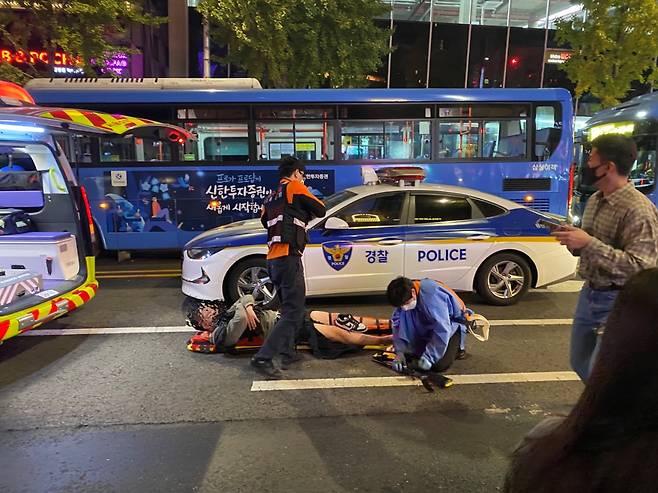 Paramedics prepare to put an injured patient on a stretcher in Itaewon, Yongsan-gu, central Seoul, at around 3:00 a.m. on Sunday. (Sanjay Kumar/The Korea Herald)