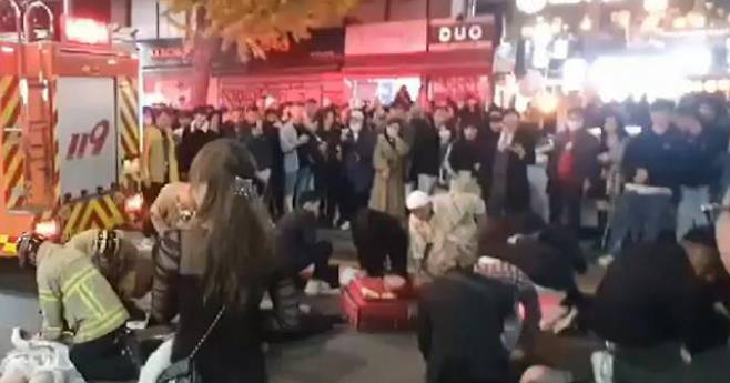 Medical workers and citizens are seen performing CPR on cardio arrest victims after a stampede in Itaewon on Saturday. (Yonhap)