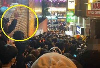 한 여성이 이태원 사고가 발생하기 수시간 전인 29일 오후 7~8시쯤 골목길 정체를 풀기 위해 일방통행을 제안하며 통솔하고 있다./틱톡