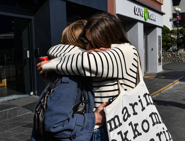 서울 이태원 참사 현장을 찾은 외국인들이 30일 이태원역 앞에 희생자들을 애도하는 조화를 놓은 뒤 눈물을 흘리며 서로 위로하고 있다. 이한결 기자