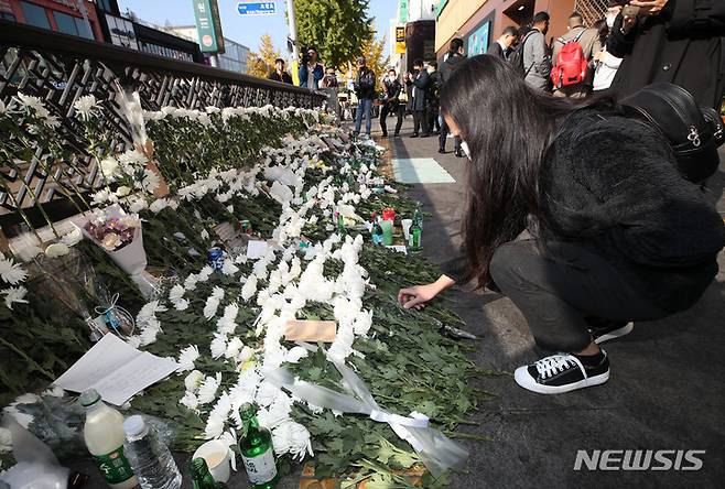 [서울=뉴시스] 조수정 기자 = 31일 오전 서울 용산구 이태원 압사 참사 현장 인근인 이태원역 1번출구 앞 희생자 추모공간에서 한 시민이 헌화하고 있다. 2022.10.31. chocrystal@newsis.com