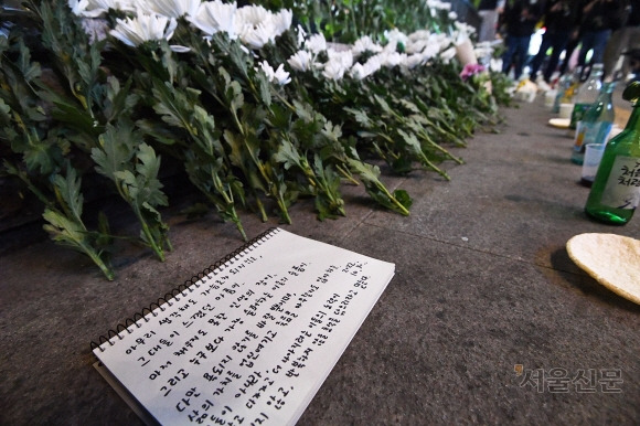 30일 저녁 서울 용산구 이태원 압사 사고 현장 인근 이태원역 1번출구 앞에 시민들이 두고 간 꽃과 추모글귀가 적힌 수첩이 놓여 있다. 2022.10.30 오장환 기자