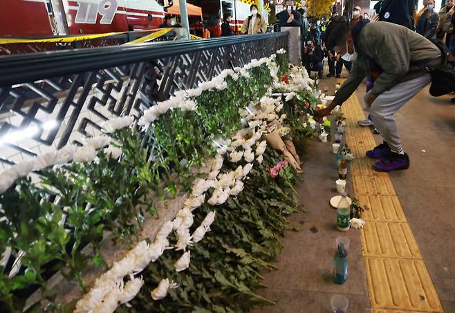 10월30일 오후 서울 용산구 지하철 6호선 이태원역 1번 출구 앞에 마련된 핼러윈 압사 사고 희생자 추모 공간을 찾은 외국인이 헌화하고 있다. ⓒ 연합뉴스