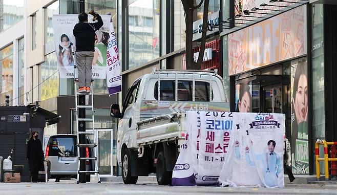 이태원 참사 희생자들을 추모하기 위해 ‘2022 코리아세일페스타’(코세페) 개막식이 취소된 31일 서울 중구 명동에서 작업자들이 코리아세일페스타 홍보 현수막을 잠시 떼어내고 있다. 코세페 주간은 예정대로 진행한다. 관계자는 국가애도기간이 끝나는 시점에 다시 홍보 현수막을 설치할 예정이라고 말했다.  연합뉴스