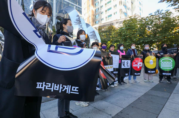 여성노동단체 관계자 등이 서울 서초구 SPC그룹 본사 앞에서 지난 10월 26일 SPL평택공장 노동자 사망사고 관련 추모 기자회견을 열고 파리바게뜨 등 SPC 계열 브랜드 포스터를 찢는 퍼포먼스를 하고 있다. / 이준헌 기자