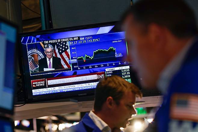 지난 7월 27일(현지 시각) 미국 뉴욕증권거래소(NYSE) 입회장 내 스크린에 제롬 파월 미국 연방준비제도(Fed) 의장의 기자회견 모습이 비치는 가운데 트레이더들이 업무를 처리하고 있다. 연준은 이날 기준금리를 0.75%포인트 올리는 '자이언트 스텝'을 단행했다. /연합뉴스