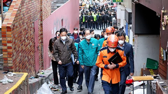 한덕수 국무총리가 31일 오후 서울 용산구 이태원 압사 사고 현장을 둘러보고 있다. 사진 왼쪽 계단과 출입구가 건축한계선을 넘은 불법 건축물이고, 벽돌과 붙어있는 분홍색 가벽도 건축물 대장에는 없는 시설물이다. 연합뉴스