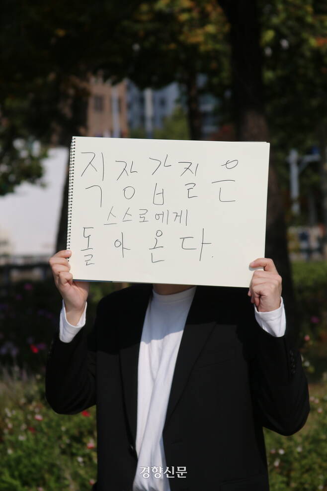 ‘성균관대 교수 갑질’을 제보한 전 대학원생 A씨(30대)가 ‘직장갑질이 만연한 한국사회에 던지고 싶은 말’을 써서 들고 있다. 조해람 기자