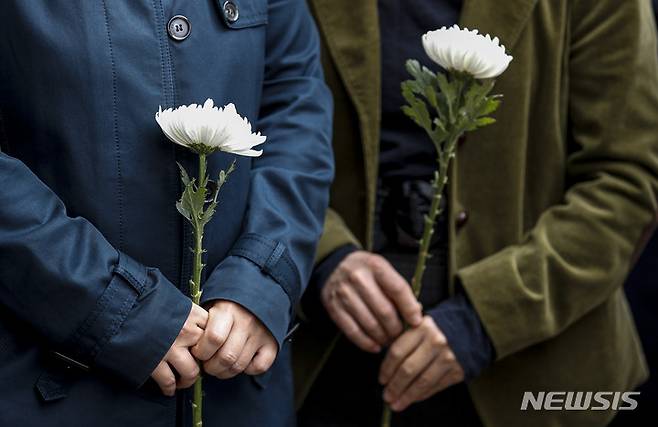 [서울=뉴시스] 정병혁 기자 = 1일 오전 서울 용산구 이태원역에 마련된 추모공간을 찾은 시민들이 조화를 들고 있다. 2022.11.01. jhope@newsis.com