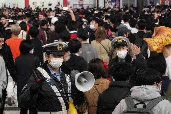 지난달 31일 일본 도쿄 시부야에서 경찰들이 확성기 등을 이용해 행인들을 안내하고 있다. AP=연합뉴스