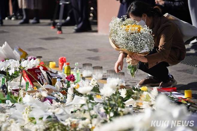 이태원 참사 발생 닷새째인 2일 오후 서울 용산구 이태원역 1번 출구 앞에 마련된 '이태원 참사' 희생자 추모공간을 찾은 한 시민이 헌화하고 있다.